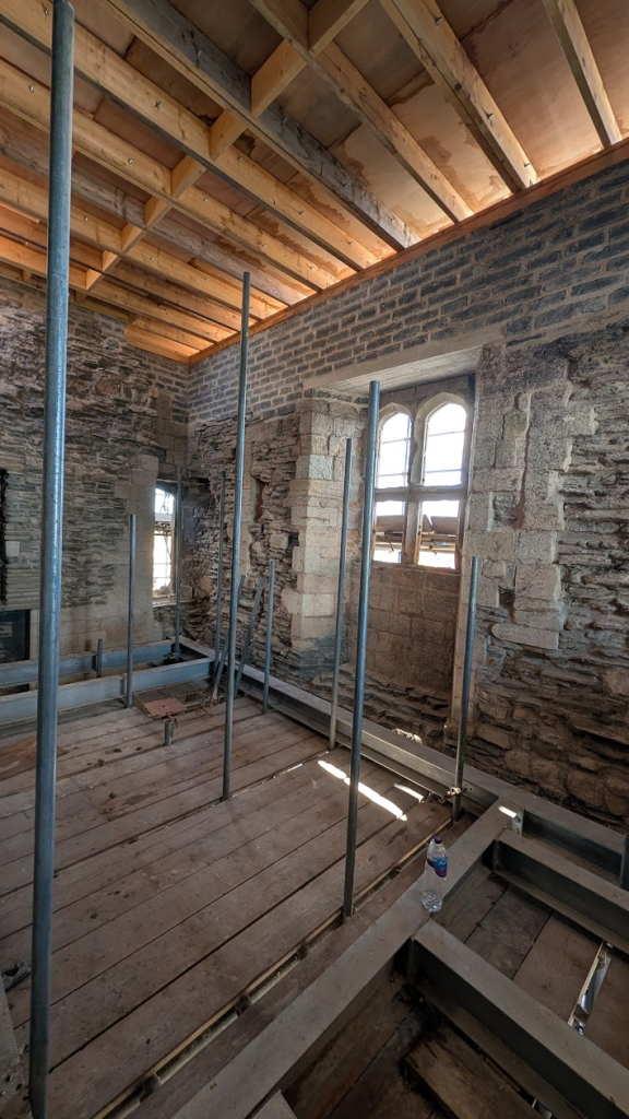 Inside medieval stone room with wooden ceiling 