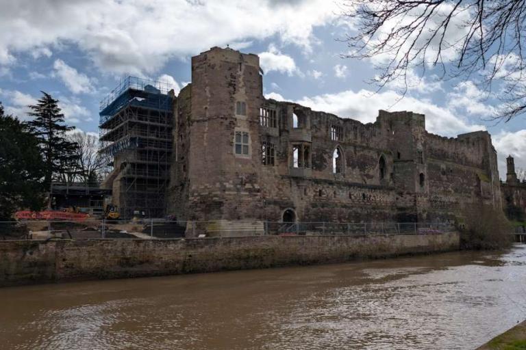 Riverside view of Newark Castle curtain wall showing a sequence of historic openings in the stonework.