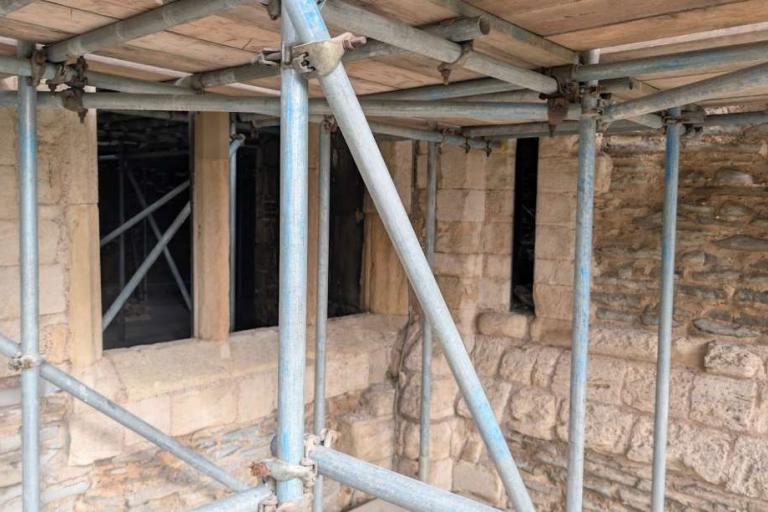 Rectangular Tudor window opening set into the Gatehouse stonework beneath scaffolding, showing later alteration to the wall.