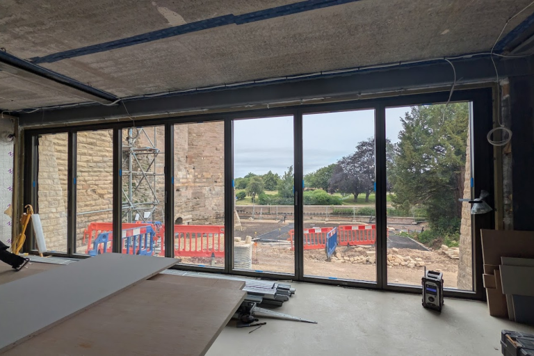 a view from inside new garden room looking towards river through large bifold doors