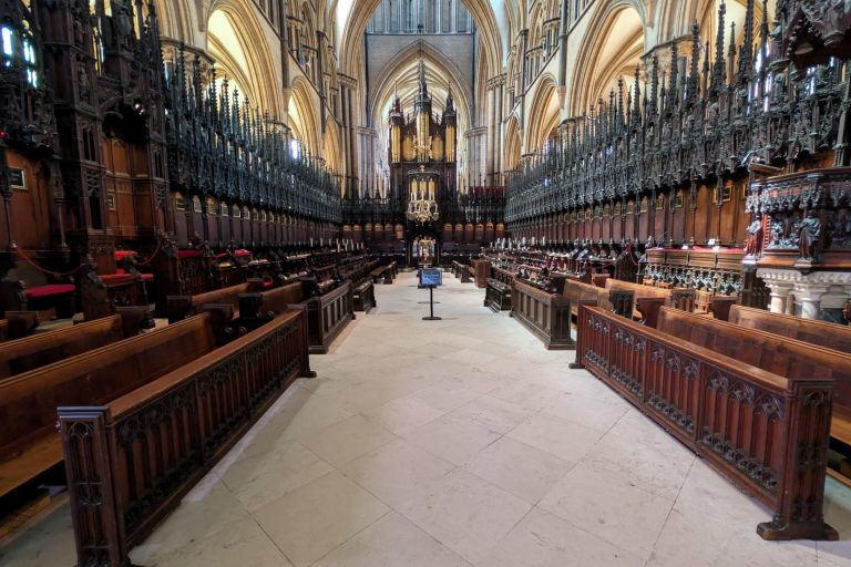 Dark wooden pews of cathedral running towards the alter
