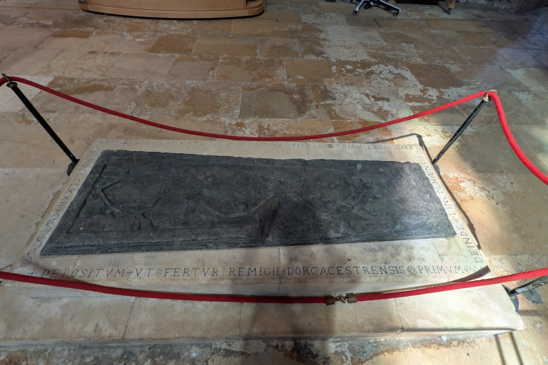 Grey gravestone embedded into the stone floor of cathedral