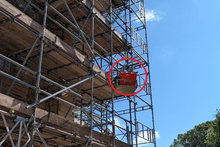 Castle gatehouse under construction with pully mechanism pulling tools to roof