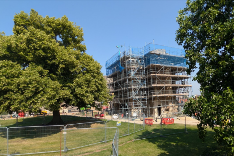 Scaffolding surrounds Newark Castle's Gatehouse as restoration work progresses beside mature trees.