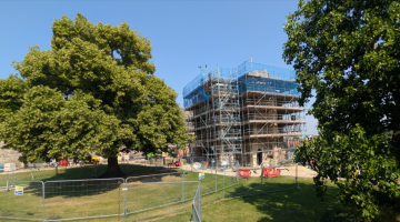 Scaffolding surrounds Newark Castle's Gatehouse as restoration work progresses beside mature trees.